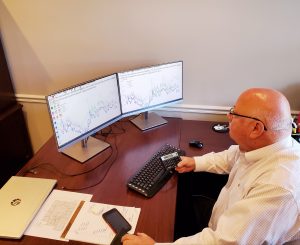 Owen Rouse, VP of investment sales, analyzing the current state of real estate asset classes on his computer.