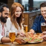 friends eating pizza with beer at restaurant friends eating pizza with beer at restaurant